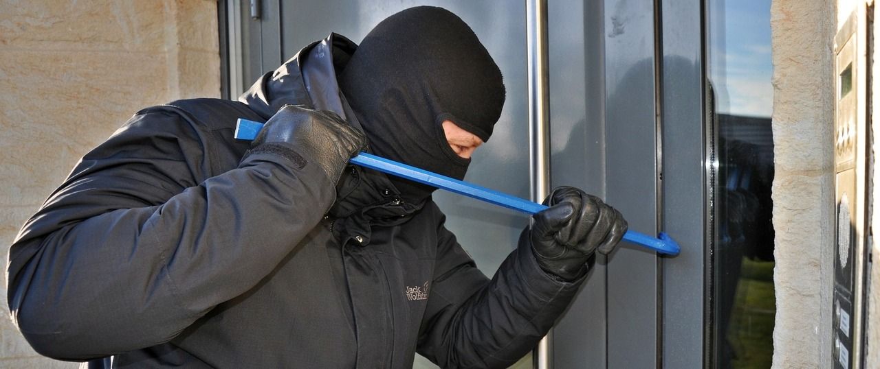 Ladrón enmascarado a la puerta de un edificio